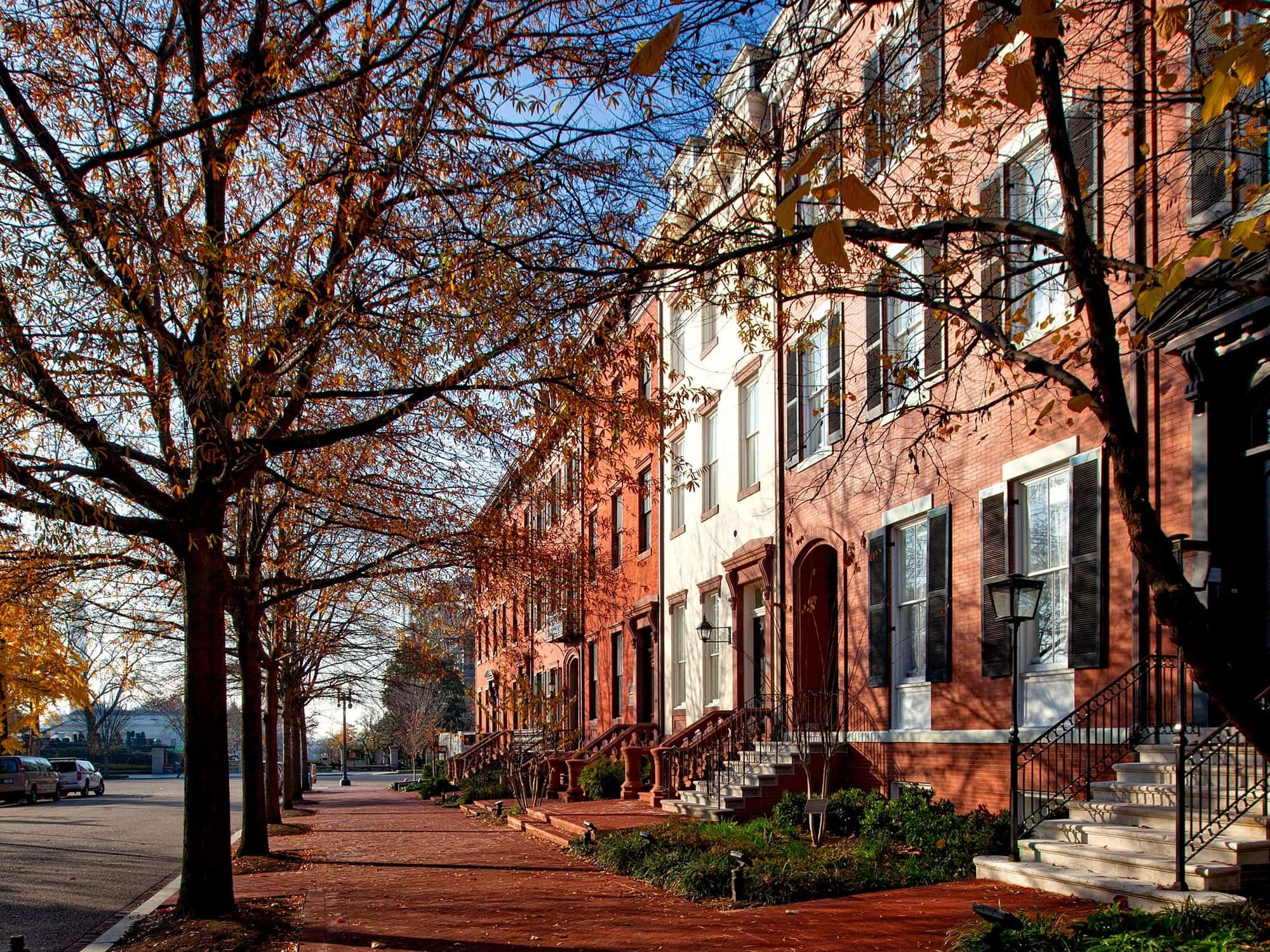 Elegant brick rowhouses along a tree-shaded brick sidewalk in Washington, DC in autumn