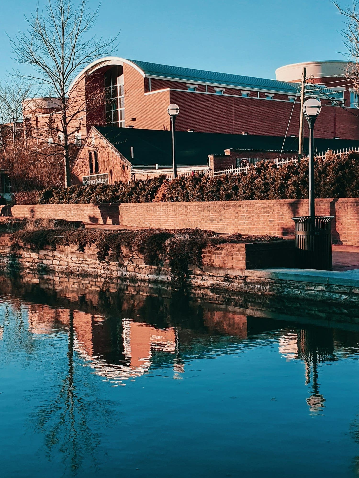 A brick building and footpath beside the water in downtown Frederick, Maryland