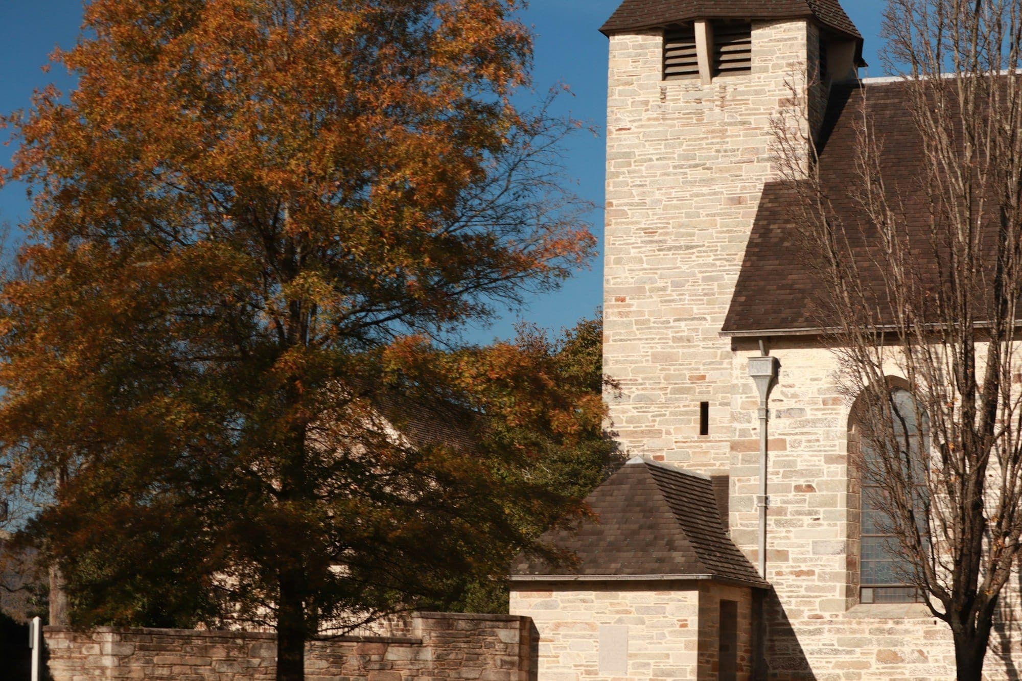 A stone church with a clock tower among autumn trees in Middleburg, Virginia