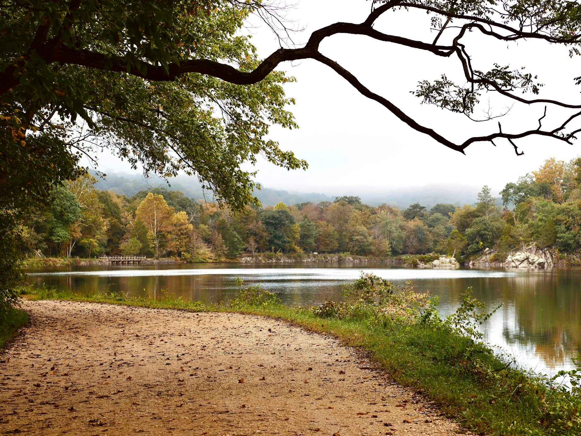 A dirt path along a calm lake at Great Falls Park in Potomac, Maryland